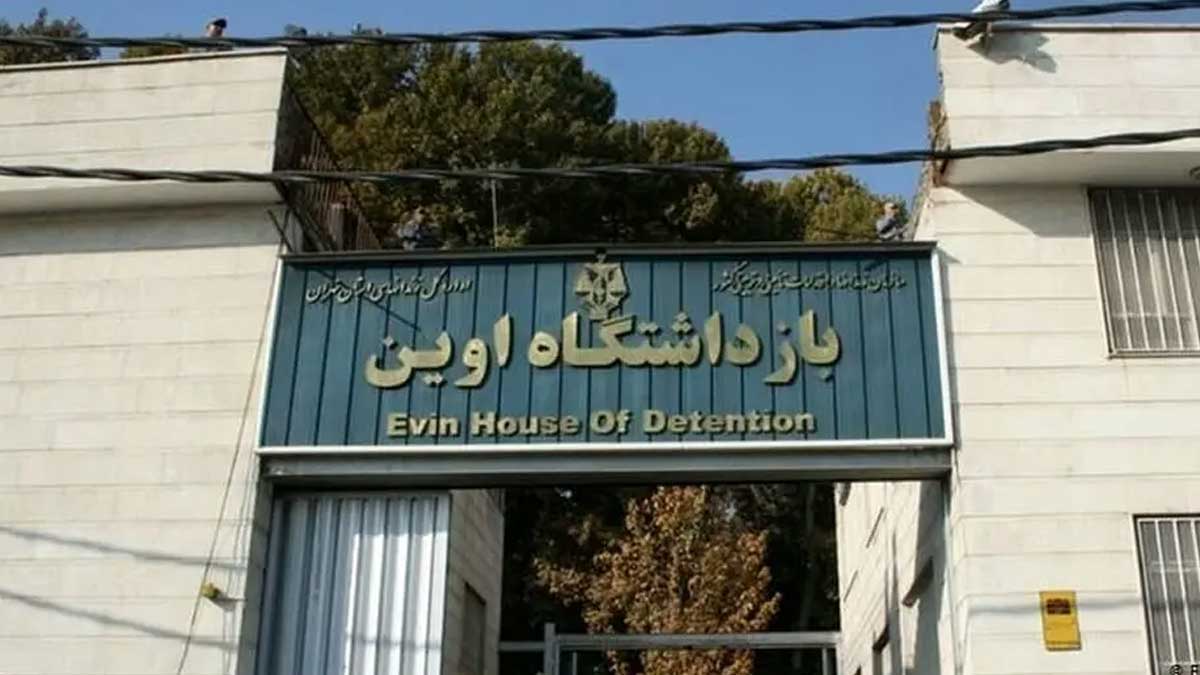 زندانیان در حال انتقال با دستبند و زنجیر از میان آوار زندان اوین