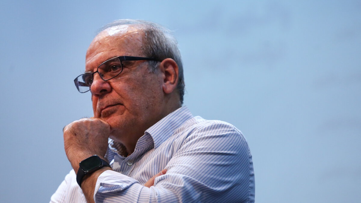 فردی در حال سخنرانی در تلویزیون با نمادهای سنتی