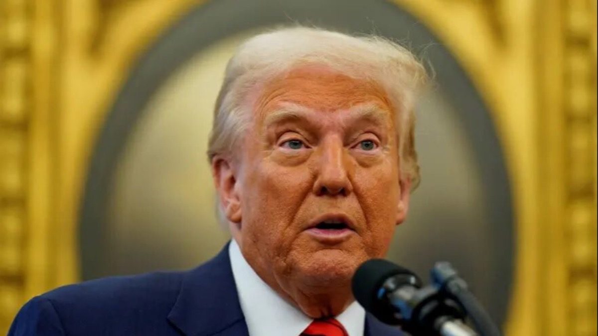 دونالد ترامپ در حال سخنرانی با پرچم آمریکا و نقشه ونزوئلا و گرینلند در پس‌زمینه